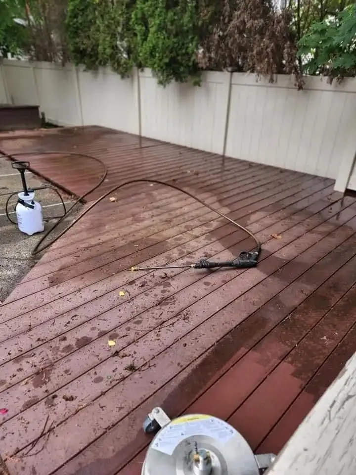 Pressure washing equipment set up on a backyard wood deck