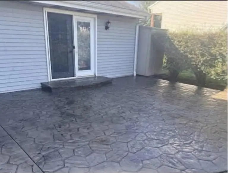 Stamped concrete patio cleaned and restored near a home entrance
