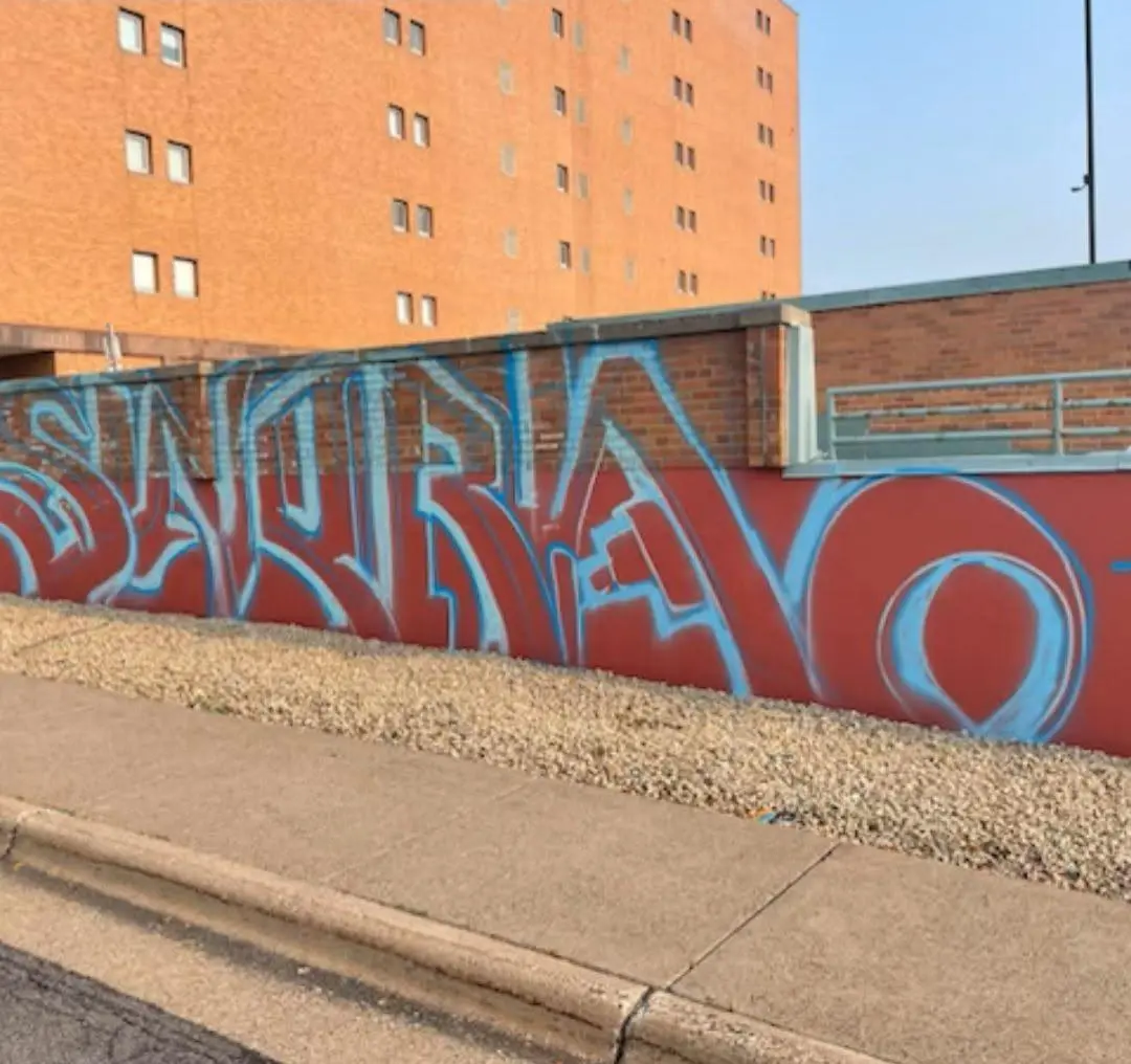 Blue spray paint tag on a Dallas parking garage wall