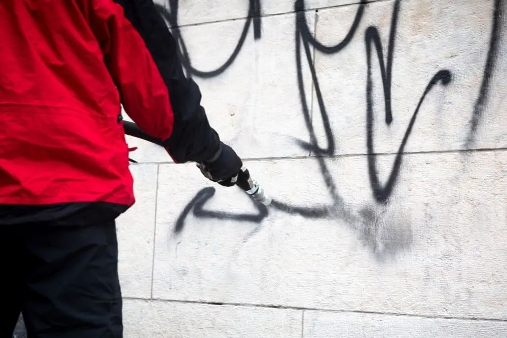 Graffiti removal companies Dallas technician cleaning a stone wall